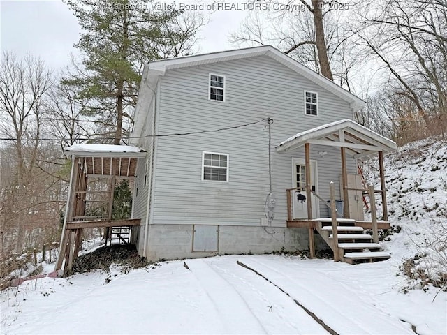 view of snow covered back of property