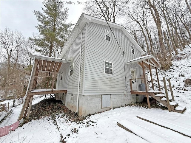 view of snow covered exterior featuring crawl space