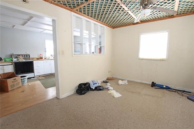 carpeted spare room with ceiling fan and baseboards