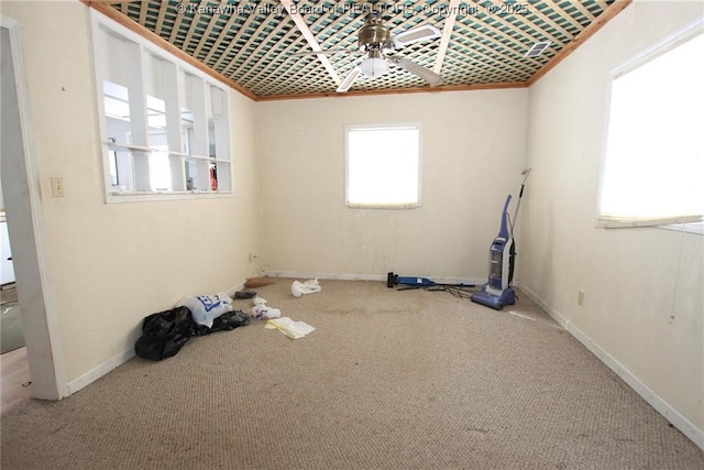 empty room featuring ornamental molding, carpet, a ceiling fan, and baseboards