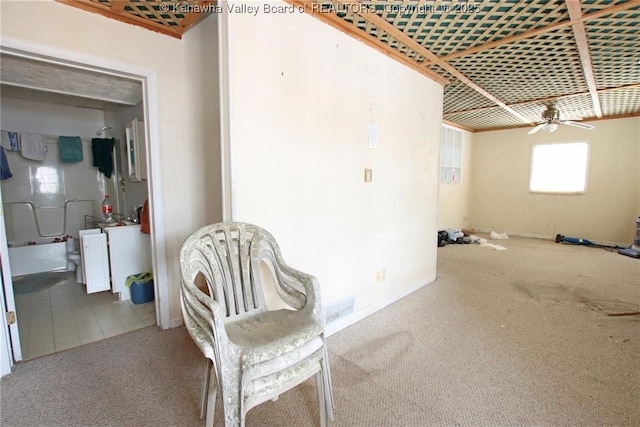 living area featuring carpet flooring, ceiling fan, and visible vents