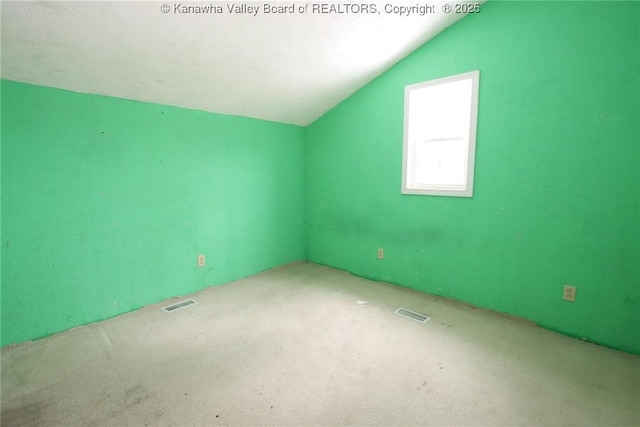 additional living space featuring vaulted ceiling and visible vents