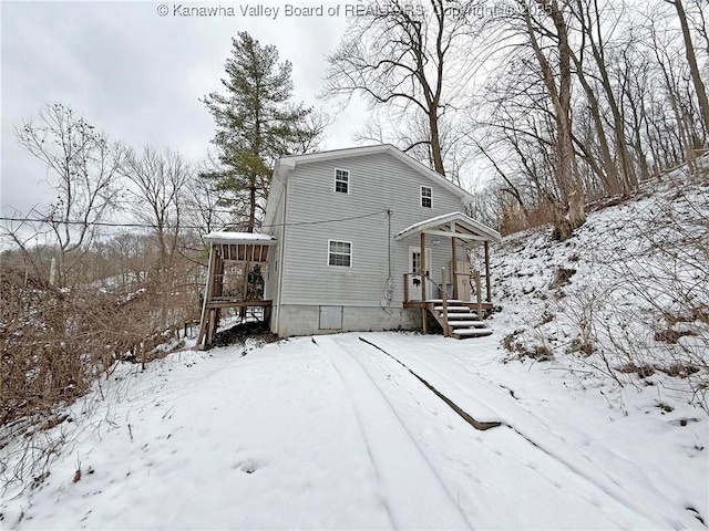 snow covered house featuring a garage