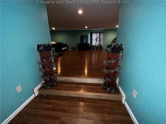 stairs with recessed lighting, baseboards, wood finished floors, and a textured wall