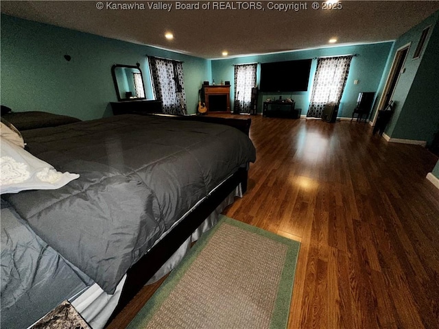 bedroom with recessed lighting, baseboards, and wood finished floors