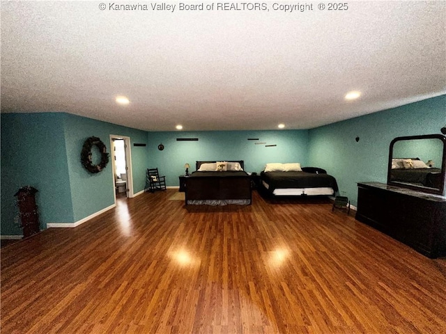 bedroom featuring dark wood-type flooring, a textured ceiling, and baseboards