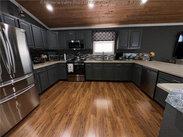 kitchen with ornamental molding, light countertops, appliances with stainless steel finishes, and a sink