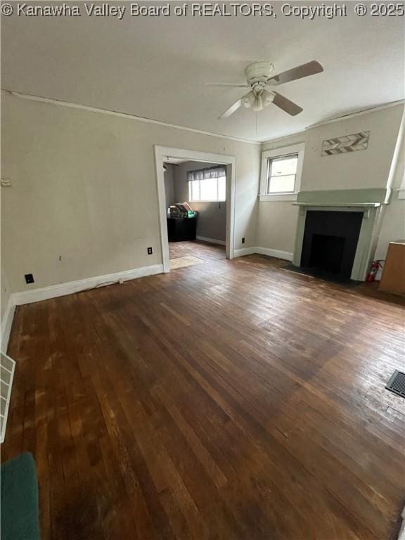 unfurnished living room with a fireplace with flush hearth, dark wood finished floors, baseboards, and a ceiling fan