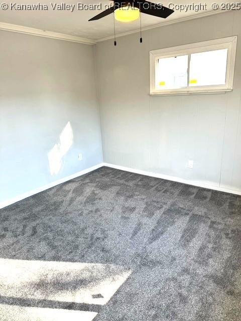 carpeted empty room featuring baseboards, ceiling fan, and crown molding