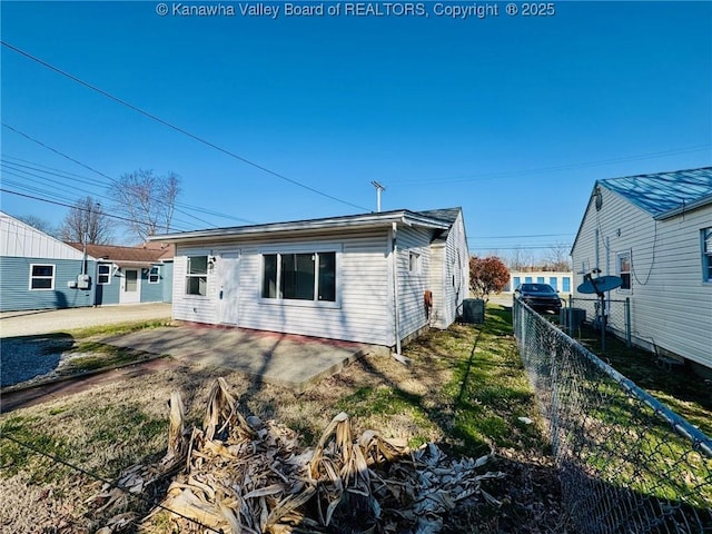 rear view of property featuring central air condition unit, a patio, and fence