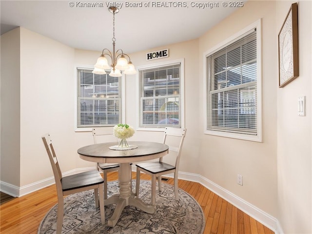 dining space featuring an inviting chandelier, wood finished floors, and baseboards