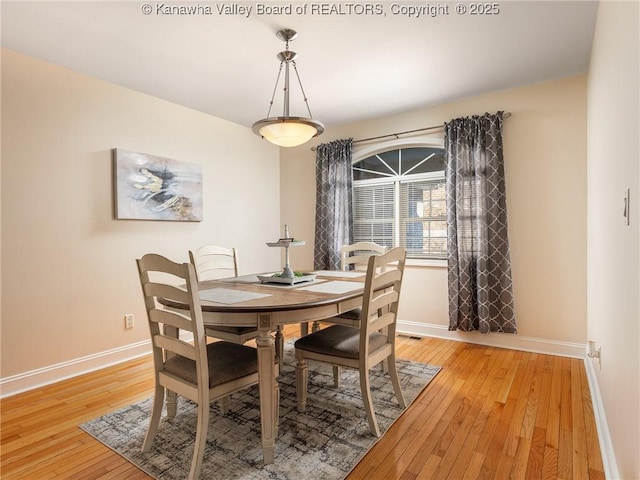 dining area with visible vents, light wood-style flooring, and baseboards