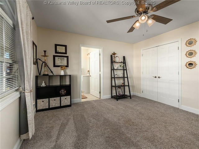 bedroom featuring a closet, light colored carpet, ceiling fan, and baseboards