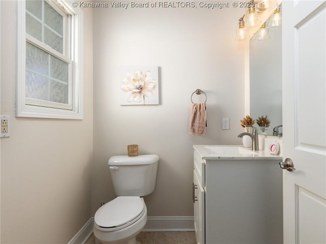 half bathroom featuring toilet, tile patterned flooring, vanity, and baseboards