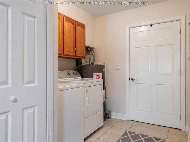 laundry area featuring baseboards, light tile patterned flooring, cabinet space, and washer and dryer