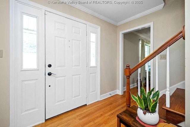 entrance foyer with light wood finished floors, baseboards, stairway, and crown molding