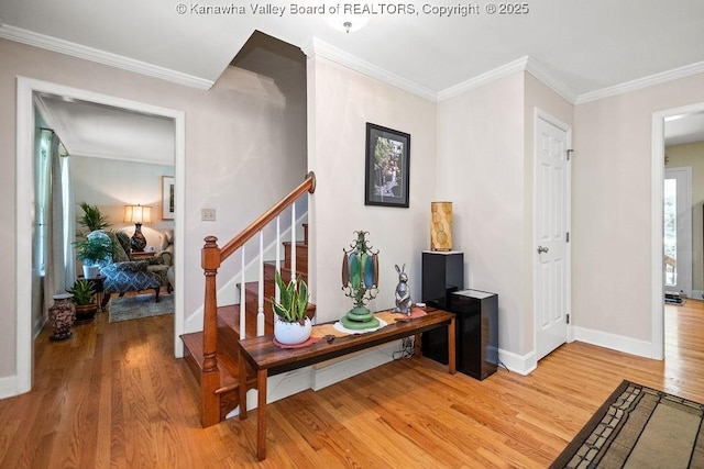 entrance foyer featuring stairs, light wood-style floors, baseboards, and crown molding