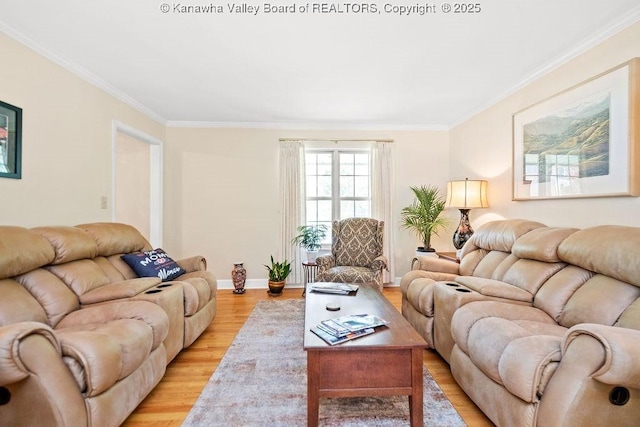 living area with baseboards, light wood-style flooring, and crown molding