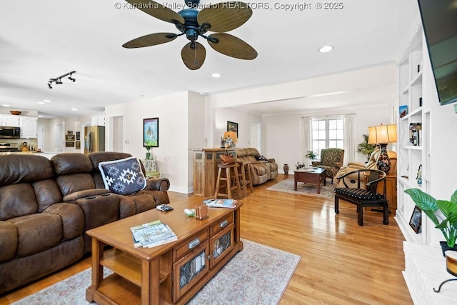 living area with baseboards, ceiling fan, recessed lighting, and light wood-style floors