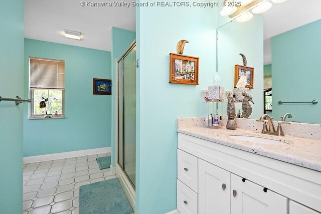 full bathroom featuring a shower stall, baseboards, and vanity