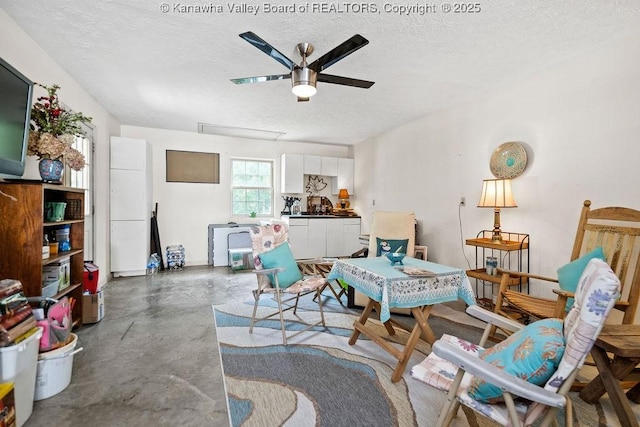 sitting room featuring concrete floors, a textured ceiling, and ceiling fan