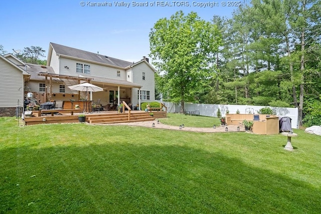 rear view of property featuring a fenced backyard, a chimney, a deck, and a yard