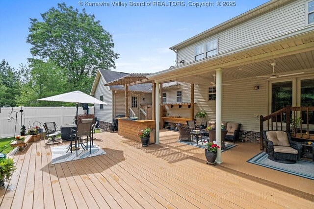 wooden terrace with fence, outdoor dining area, and a pergola