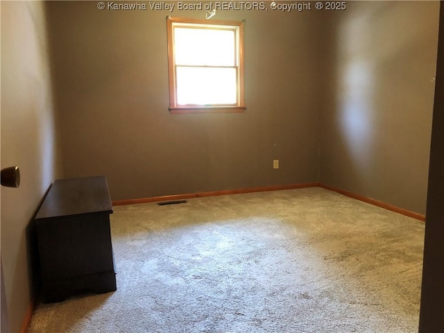 empty room with visible vents, baseboards, and carpet flooring