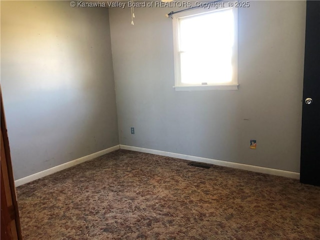 unfurnished room with carpet flooring, visible vents, and baseboards