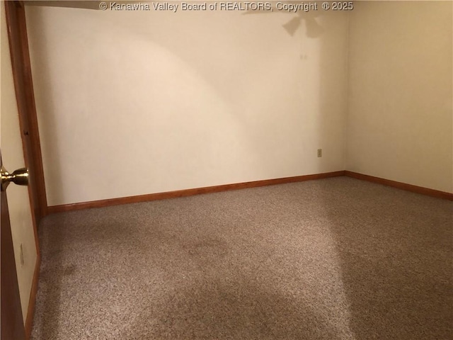 spare room featuring carpet flooring and baseboards