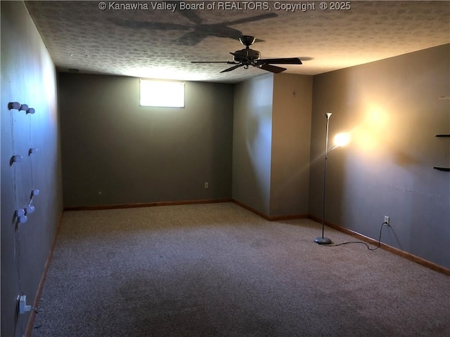 carpeted empty room featuring a textured ceiling, a ceiling fan, and baseboards