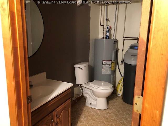 half bath with water heater, vanity, toilet, and tile patterned floors