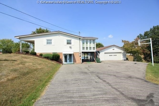 view of front of home with a garage, an outbuilding, and a front yard