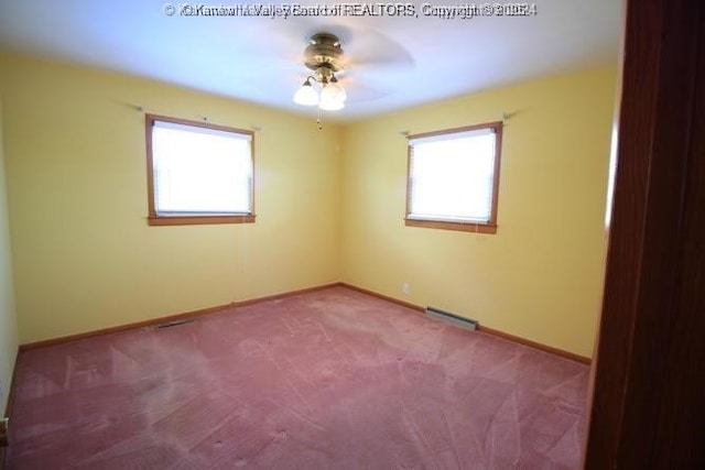 spare room featuring carpet, visible vents, ceiling fan, and baseboards