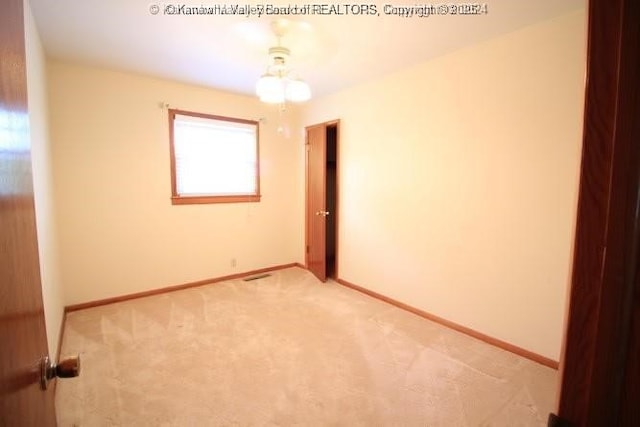 unfurnished room with baseboards and light colored carpet