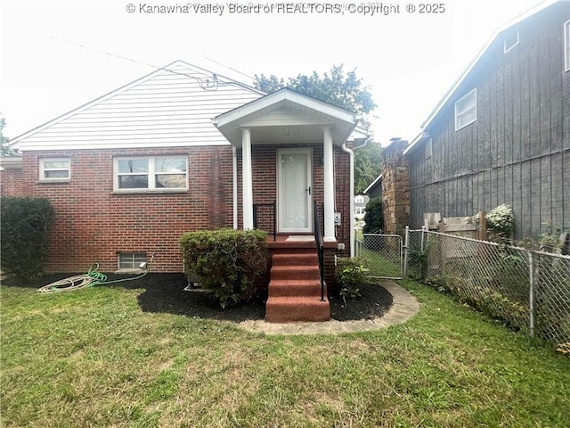 view of front of property featuring a front yard, a gate, brick siding, and fence