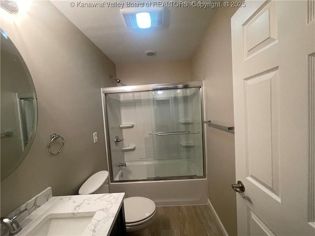 full bathroom with toilet, wood finished floors, visible vents, vanity, and combined bath / shower with glass door