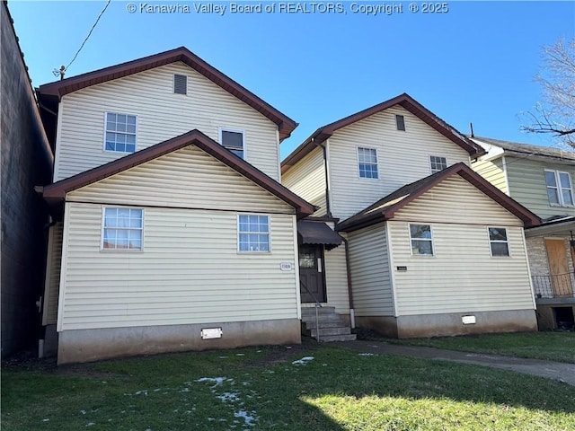 rear view of property with entry steps and a yard