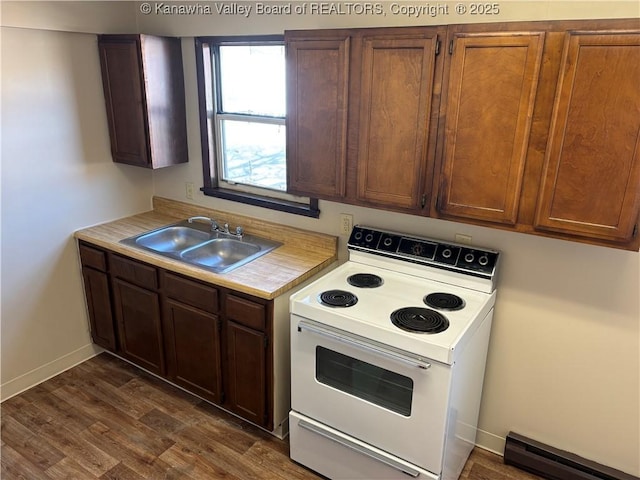 kitchen featuring dark wood-style flooring, light countertops, electric range, a baseboard heating unit, and a sink