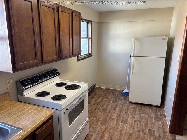 kitchen featuring light countertops, white appliances, wood finished floors, and baseboards