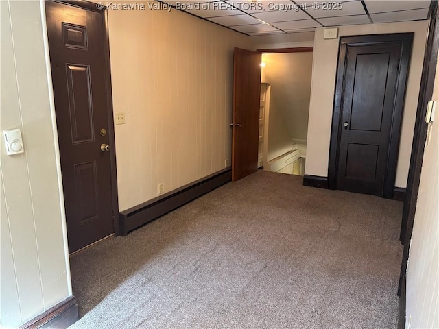 unfurnished room featuring carpet floors, a baseboard radiator, a drop ceiling, and baseboard heating