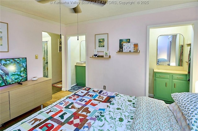 bedroom featuring a ceiling fan, crown molding, ensuite bath, and wood finished floors