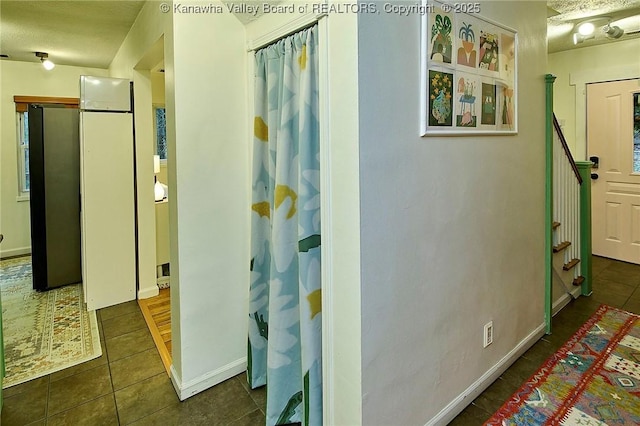 hall with baseboards, stairway, and tile patterned floors