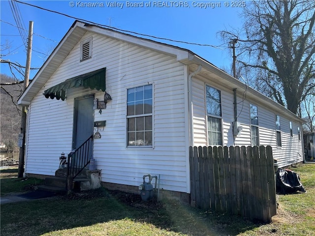 view of side of home featuring entry steps and fence