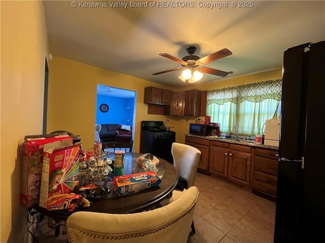 kitchen featuring a sink, black appliances, a ceiling fan, and light tile patterned flooring