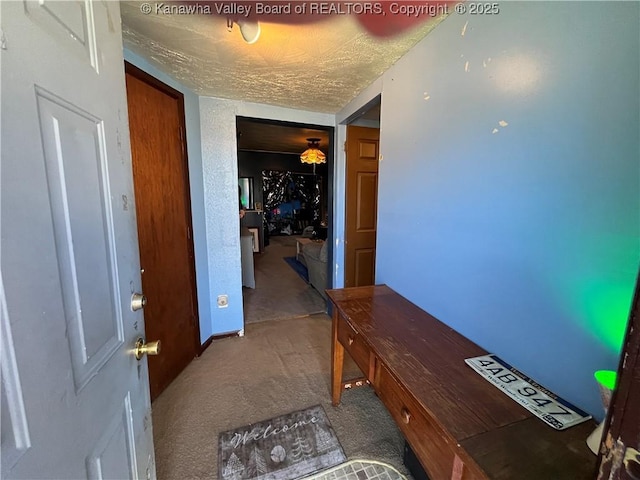 hall featuring carpet and a textured ceiling