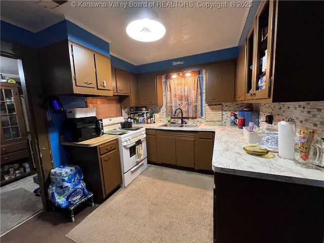 kitchen with backsplash, electric range, light countertops, and a sink