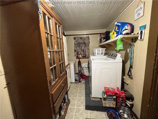 clothes washing area with laundry area, light floors, washing machine and dryer, and crown molding