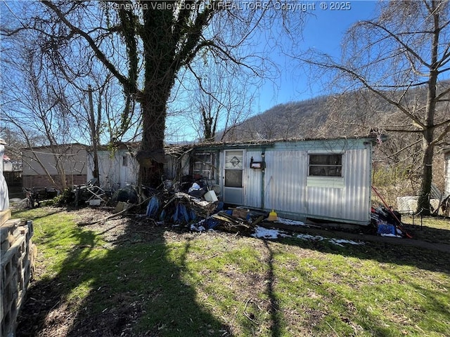 rear view of property featuring a lawn