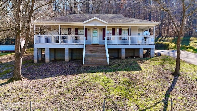 view of front of house with stairs, a porch, and roof with shingles